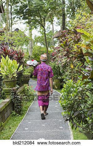 Picture - Balinese worker walking along path. Fotosearch