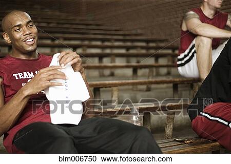 Stock Image - Basketball players sitting in bleachers. Fotosearch