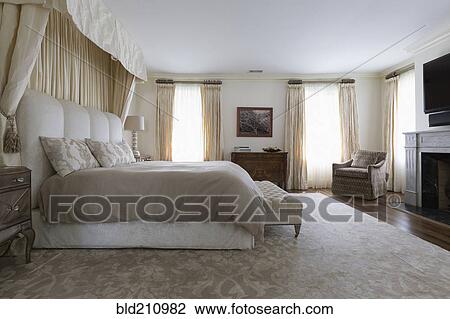 Stock Image - Bench and bed in ornate bedroom. Fotosearch