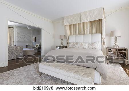 Stock Photo - Bench and bed in ornate bedroom. Fotosearch