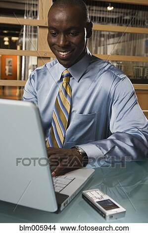 Black businessman typing on laptop View Large Photo Image Picture - Black businessman typing on laptop. Fotosearch