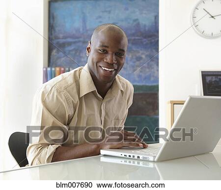 Stock Image - Black businessman typing on laptop. Fotosearch