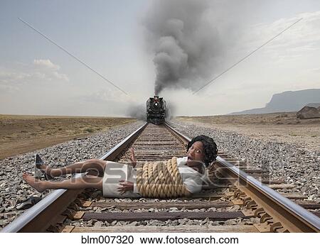 Black businesswoman tied to train tracks View Large Photo Image Stock Image - Black businesswoman tied to train tracks. Fotosearch