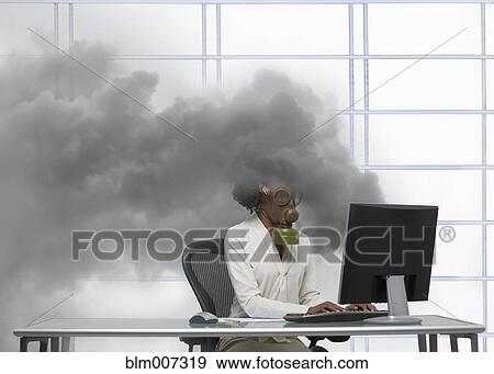Stock Photo - Black businesswoman wearing gas mask at smoking computer. Fotosearch