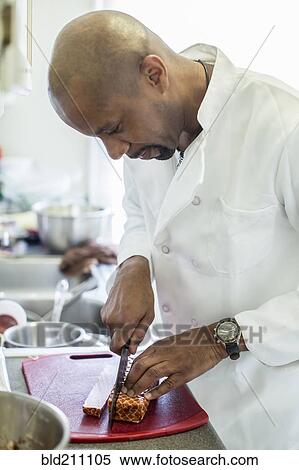 Stock Photography - Black chef working in kitchen. Fotosearch