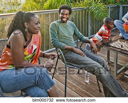 Black family relaxing on patio View Large Photo Image Stock Image - Black family relaxing on patio. Fotosearch