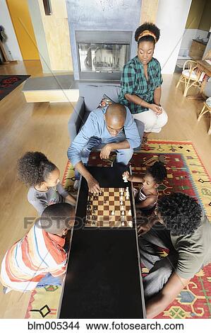 Picture - Black family watching chess game. Fotosearch