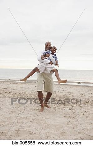 Black father and son playing at the beach View Large Photo Image Stock Photo - Black father and son playing at the beach. Fotosearch
