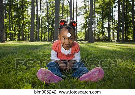 Black girl sitting in grass View Large Photo Image Stock Image - Black girl sitting in grass. Fotosearch