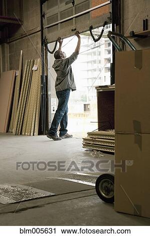 Black man closing loading dock door in warehouse View Large Photo Image Stock Image - Black man closing loading dock door in warehouse. Fotosearch