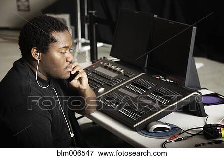 Black man listening to sound mixing equipment View Large Photo Image Stock Photo - Black man listening to sound mixing equipment. Fotosearch