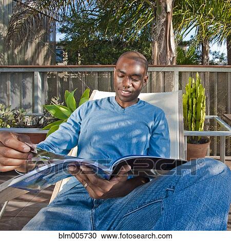 Black man reading book on patio View Large Photo Image Stock Image - Black man reading book on patio. Fotosearch