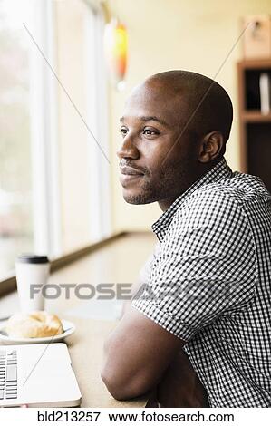 Stock Photo - Black man relaxing in coffee shop. Fotosearch