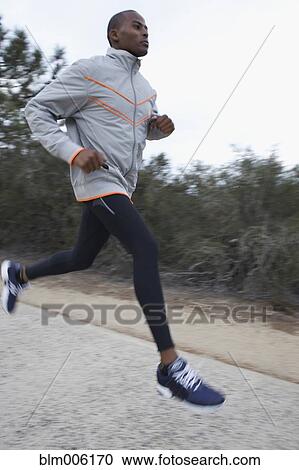 Stock Image - Black man running on road. Fotosearch