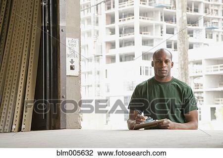 Black man standing near warehouse loading dock View Large Photo Image Stock Image - Black man standing near warehouse loading dock. Fotosearch
