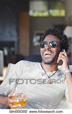 Black man talking on cell phone and drinking View Large Photo Image Stock Image - Black man talking on cell phone and drinking. Fotosearch