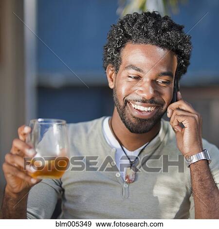 Black man talking on cell phone and drinking View Large Photo Image Stock Photo - Black man talking on cell phone and drinking. Fotosearch