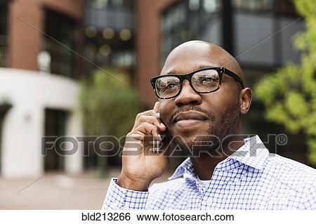 Stock Photograph - Black man talking on cell phone in city. Fotosearch