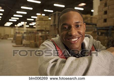 Stock Photo - Black man working in warehouse. Fotosearch