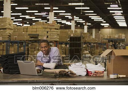 Stock Photograph - Black man working in warehouse. Fotosearch