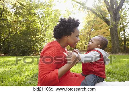 Black mother and toddler son playing in park View Large Photo Image Stock Photography - Black mother and toddler son playing in park. Fotosearch