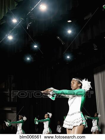 Stock Image - Black student dance team performing on stage. Fotosearch