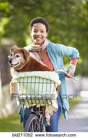 Black woman carrying dog in bicycle basket View Large Photo Image Stock Image - Black woman carrying dog in bicycle basket. Fotosearch
