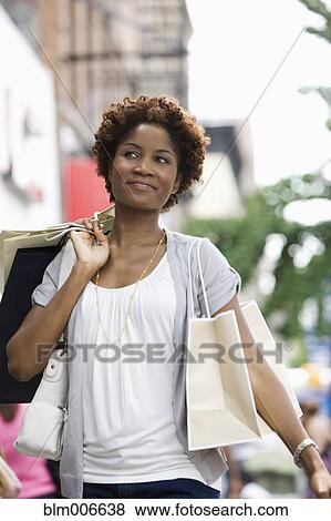 Black woman carrying shopping bags in city View Large Photo Image Stock Photo - Black woman carrying shopping bags in city. Fotosearch