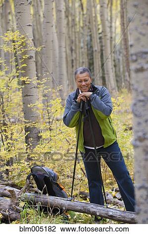 Stock Image - Black woman hiking in forest. Fotosearch
