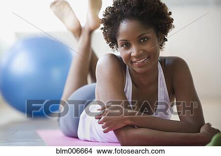 Black woman laying on floor on yoga mat View Large Photo Image Picture - Black woman laying on floor on yoga mat. Fotosearch
