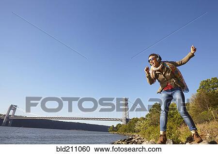 Black woman listening to headphones at river View Large Photo Image Stock Image - Black woman listening to headphones at river. Fotosearch