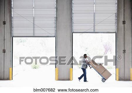 Black woman moving boxes in empty warehouse View Large Photo Image Stock Image - Black woman moving boxes in empty warehouse. Fotosearch