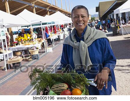 Stock Photograph - Black woman shopping in farmer's market. Fotosearch