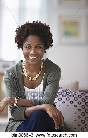 Black woman sitting in living room View Large Photo Image Stock Image - Black woman sitting in living room. Fotosearch