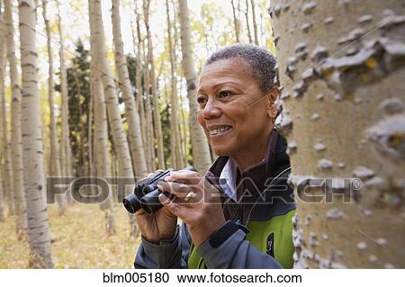 Black woman using binoculars in forest View Large Photo Image Stock Image - Black woman using binoculars in forest. Fotosearch