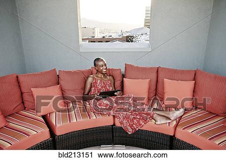 Black woman using digital tablet on urban rooftop View Large Photo Image Stock Image - Black woman using digital tablet on urban rooftop. Fotosearch