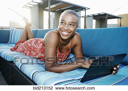 Black woman using digital tablet on urban rooftop View Large Photo Image Stock Image - Black woman using digital tablet on urban rooftop. Fotosearch