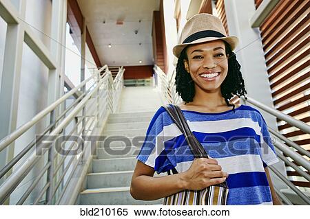 Stock Photography - Black woman walking down steps. Fotosearch