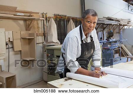 Stock Photo - Black woman working in carpentry shop. Fotosearch