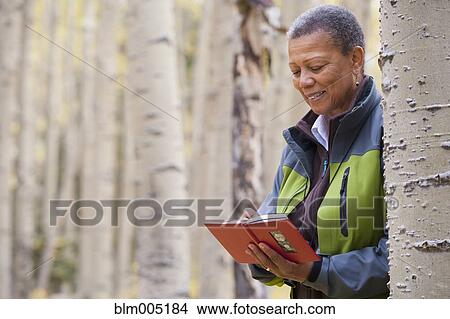 Black woman writing in diary in forest View Large Photo Image Picture - Black woman writing in diary in forest. Fotosearch