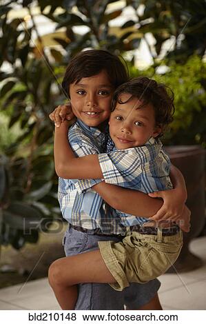 Boy holding brother on porch View Large Photo Image Stock Photo - Boy holding brother on porch. Fotosearch