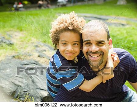 Boy hugging father outdoors View Large Photo Image Stock Image - Boy hugging father outdoors. Fotosearch