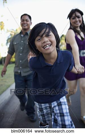 Picture - Boy laughing and pulling mother and father. Fotosearch