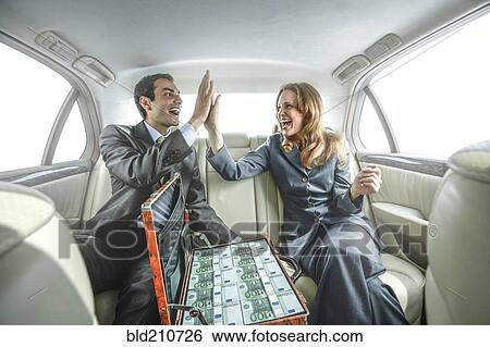 Business people high fiving in backseat of car View Large Photo Image Stock Photograph - Business people high fiving in backseat of car. Fotosearch