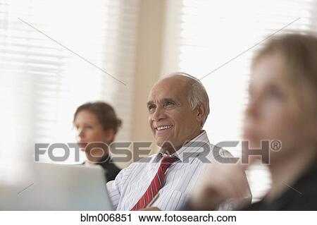 Stock Image - Business people listening in meeting. Fotosearch