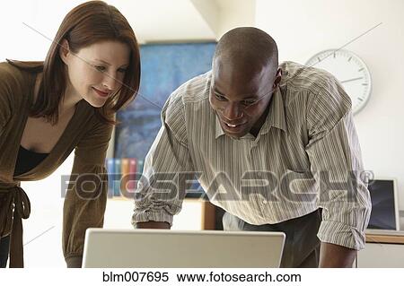 Business people looking at laptop View Large Photo Image Stock Photography - Business people looking at laptop. Fotosearch