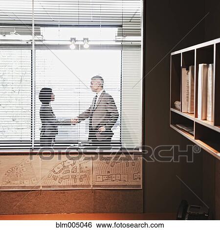 Stock Photograph - Business people shaking hands in office. Fotosearch