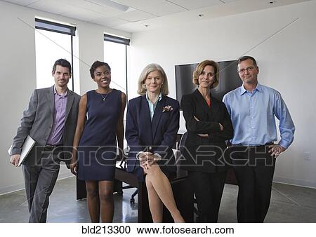 Stock Image - Business people smiling together in office. Fotosearch