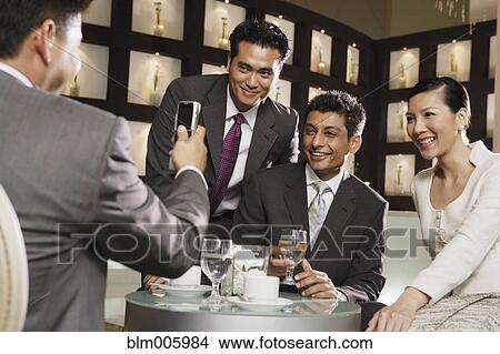 Business people taking photographs with cell phone View Large Photo Image Picture - Business people taking photographs with cell phone. Fotosearch