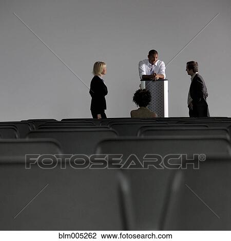 Business people talking in empty auditorium View Large Photo Image Stock Image - Business people talking in empty auditorium. Fotosearch